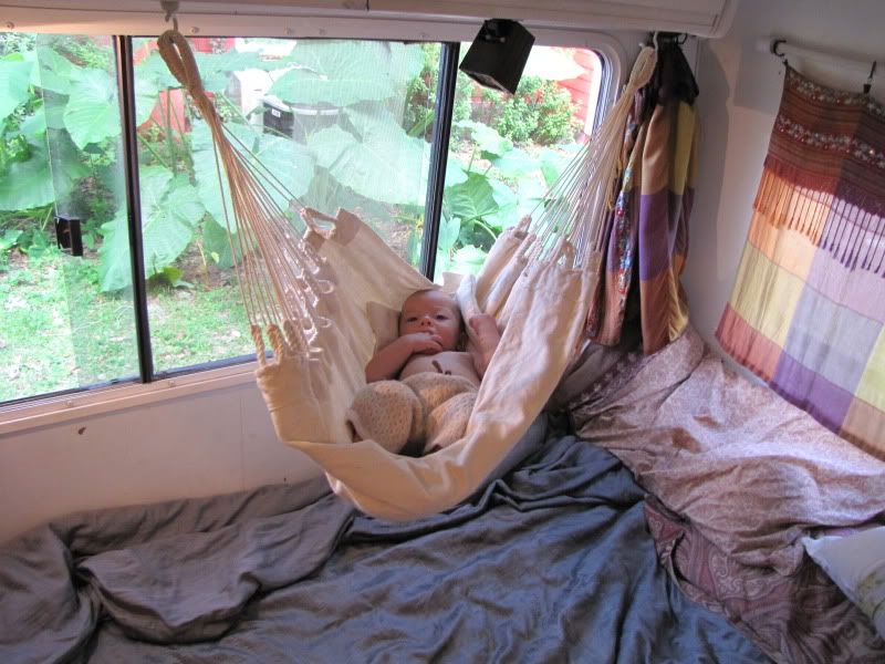 Baby in Baby Hammock above bed.